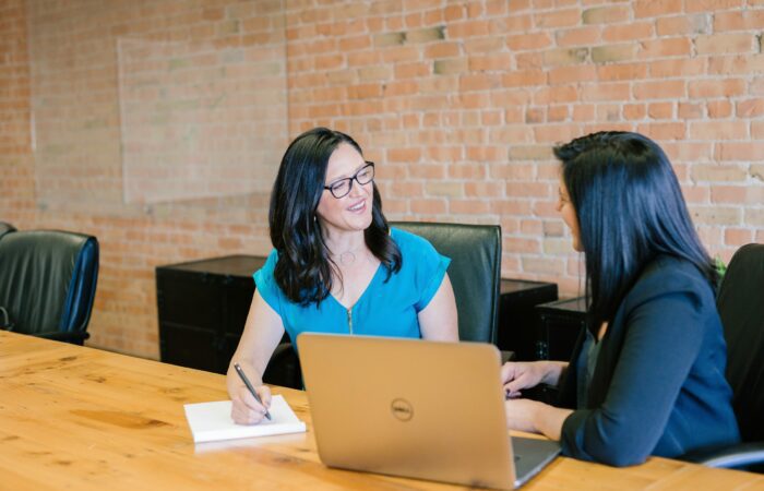 Two women inside office laughing together
