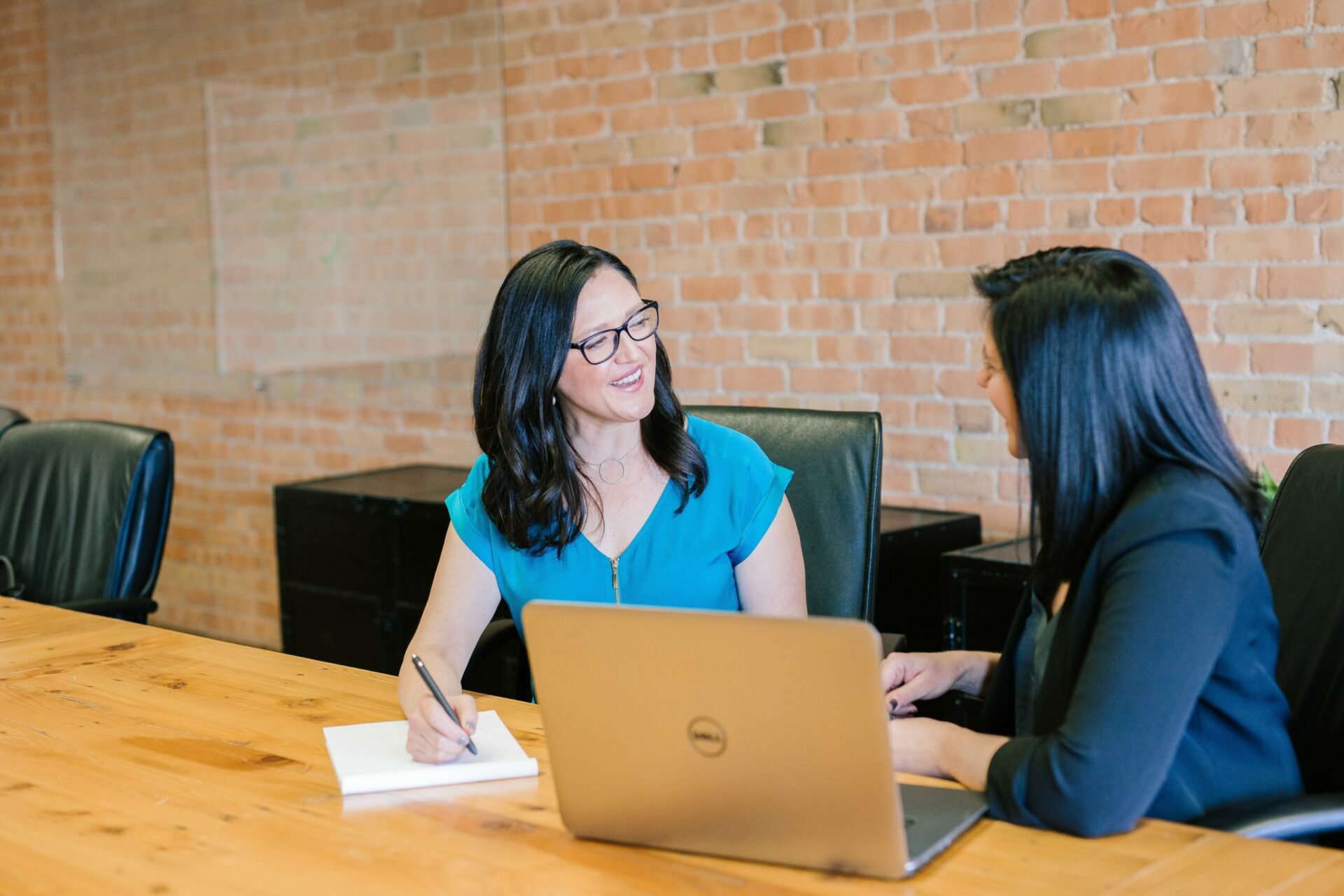 Two women inside office laughing together