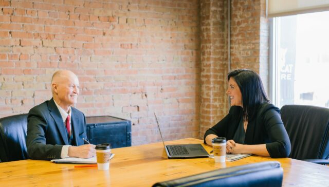 Man and woman inside office laughing together