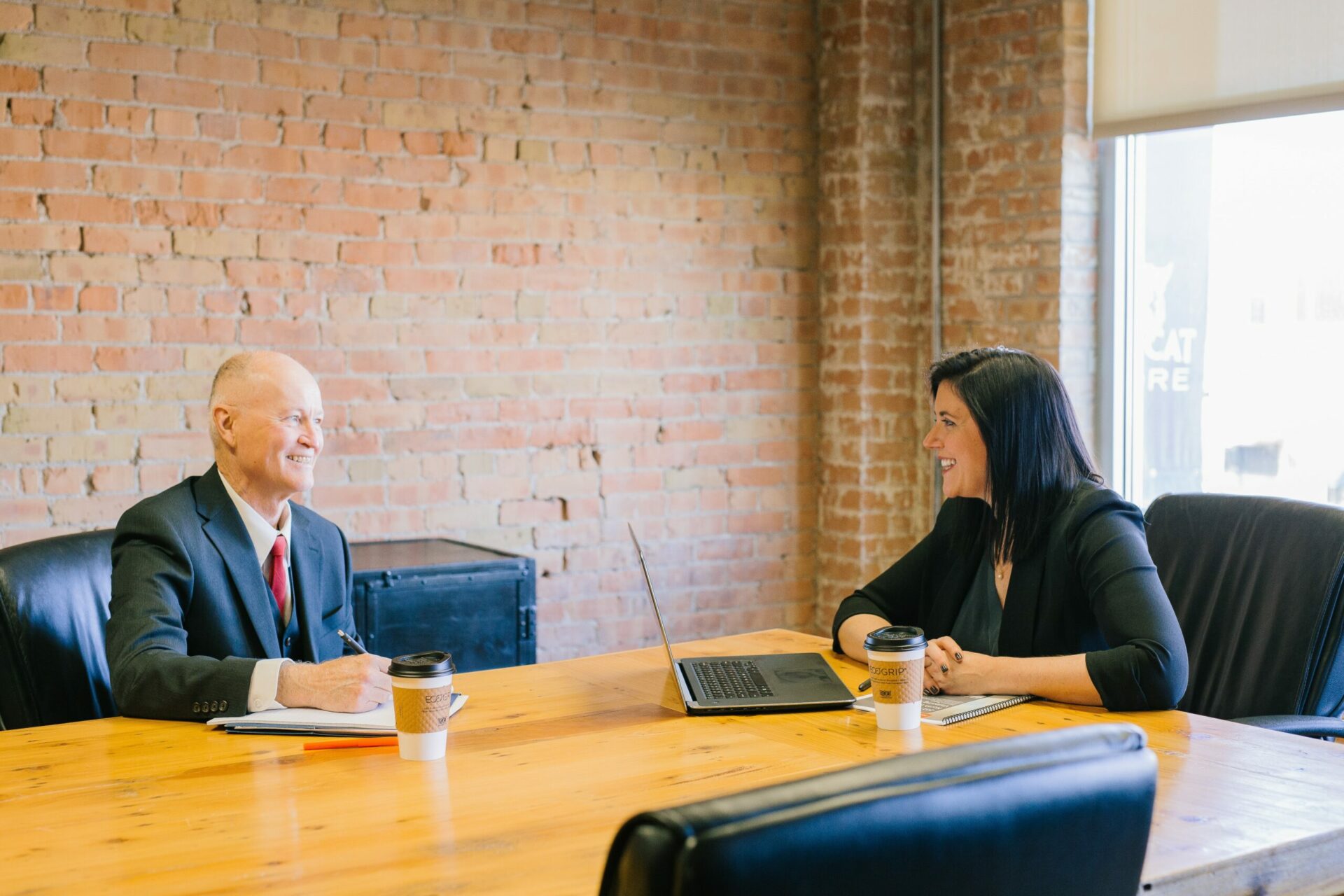 Man and woman inside office laughing together