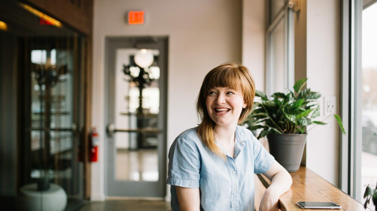 Happy woman sitting at window table looking into the distance