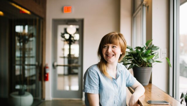 Happy woman sitting at window table looking into the distance