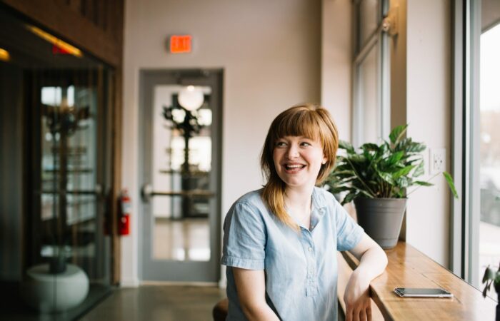 Happy woman sitting at window table looking into the distance