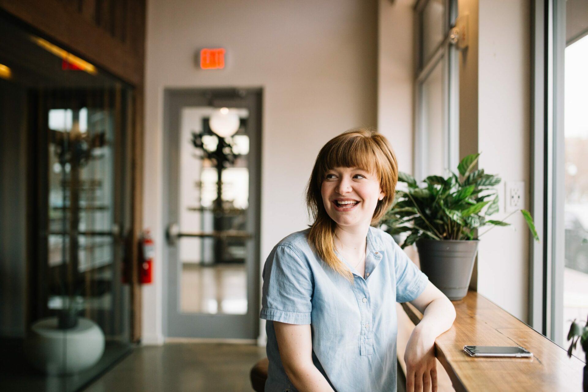 Happy woman sitting at window table looking into the distance