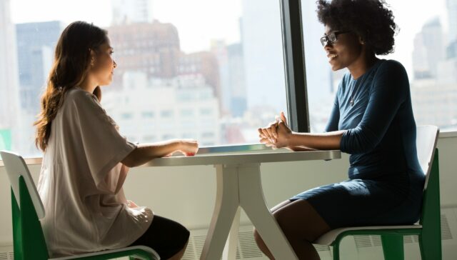 Two women discussing something at a table