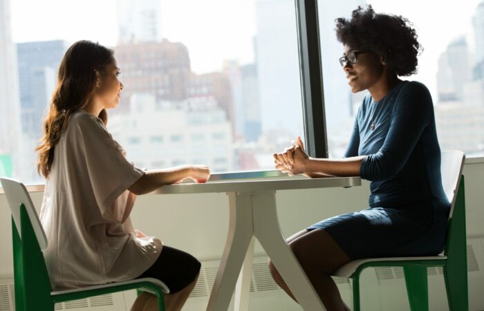 Two women discussing something at a table