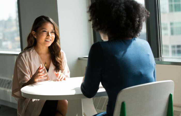 Two women discussing something at a table