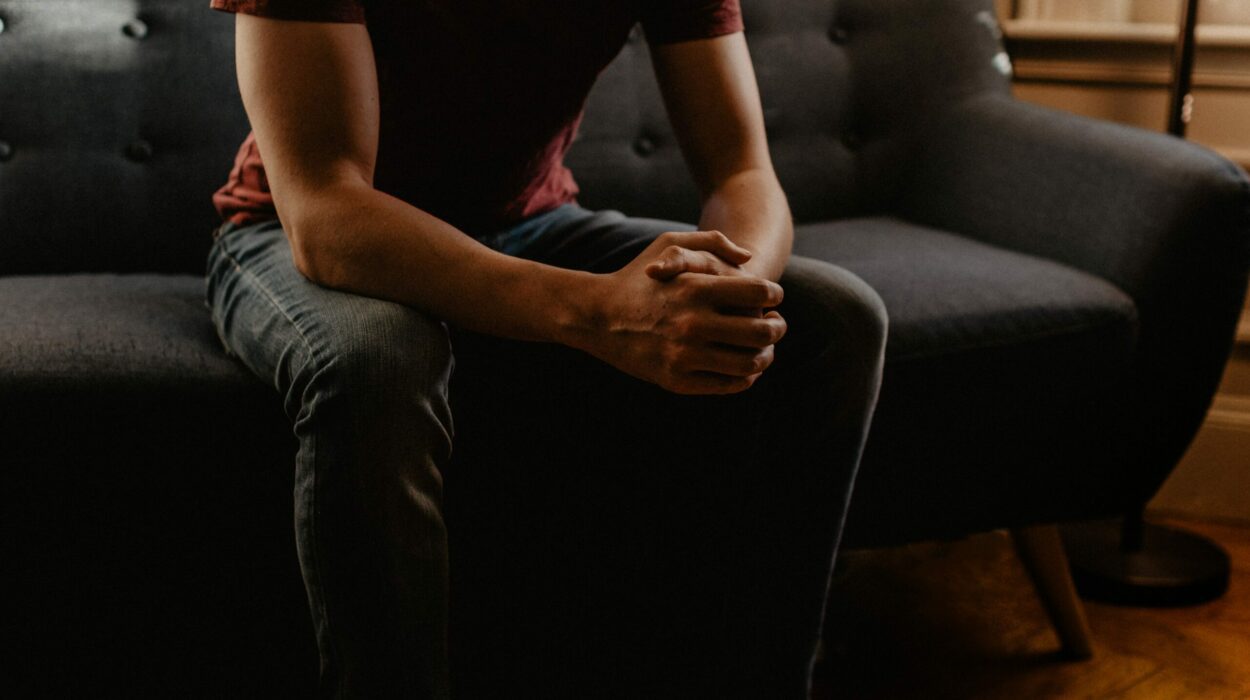 Young man sitting on a couch with his hands locked