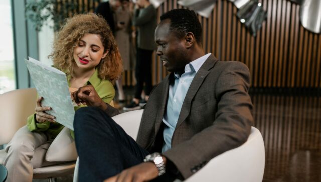 Man and woman discussing business by looking at a brochure
