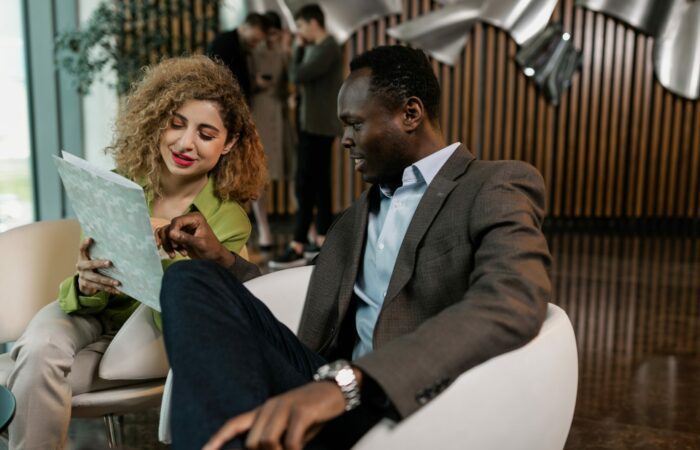 Man and woman discussing business by looking at a brochure