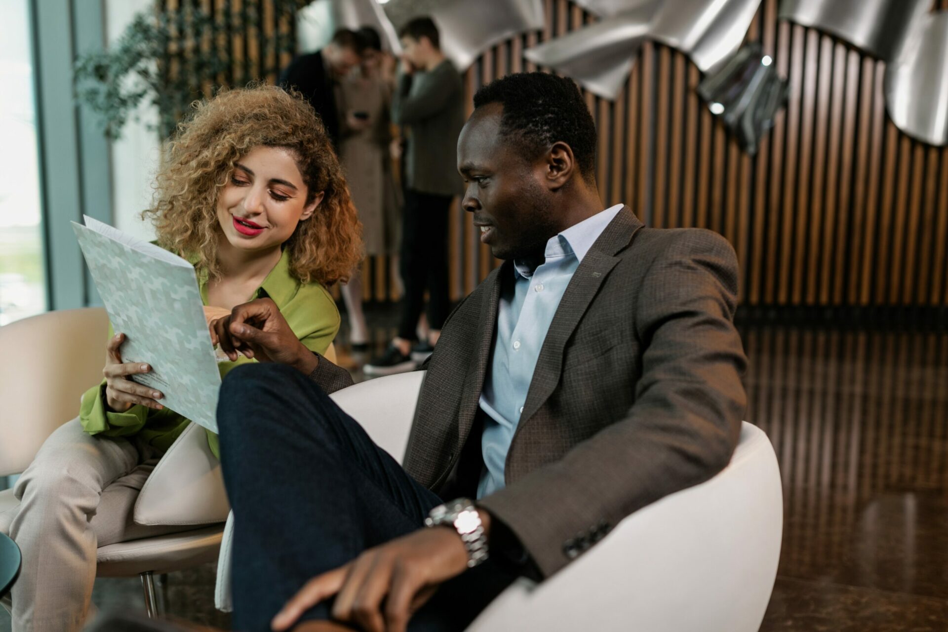 Man and woman discussing business by looking at a brochure