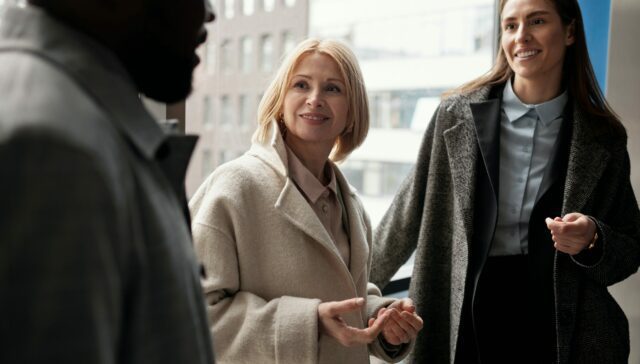 Two women and a man are in an informal and friendly conversation