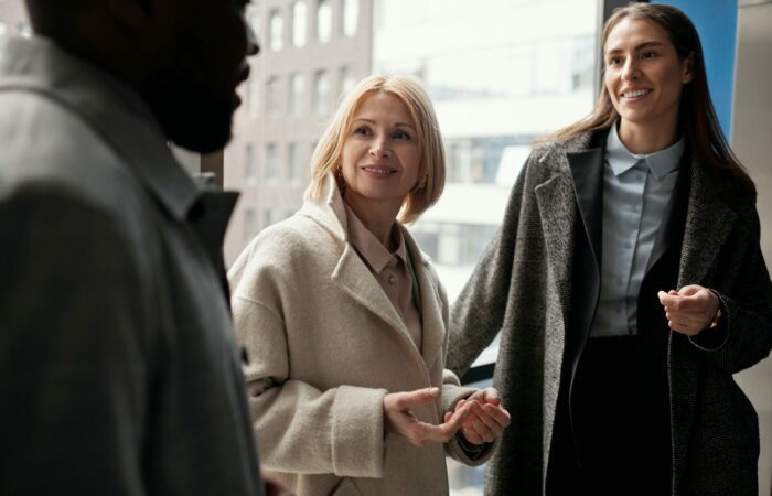 Two women and a man are in an informal and friendly conversation