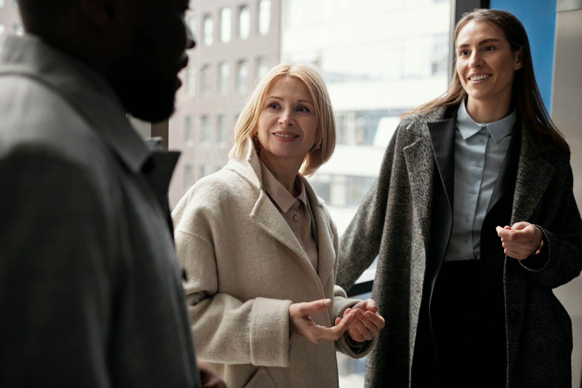 Two women and a man are in an informal and friendly conversation