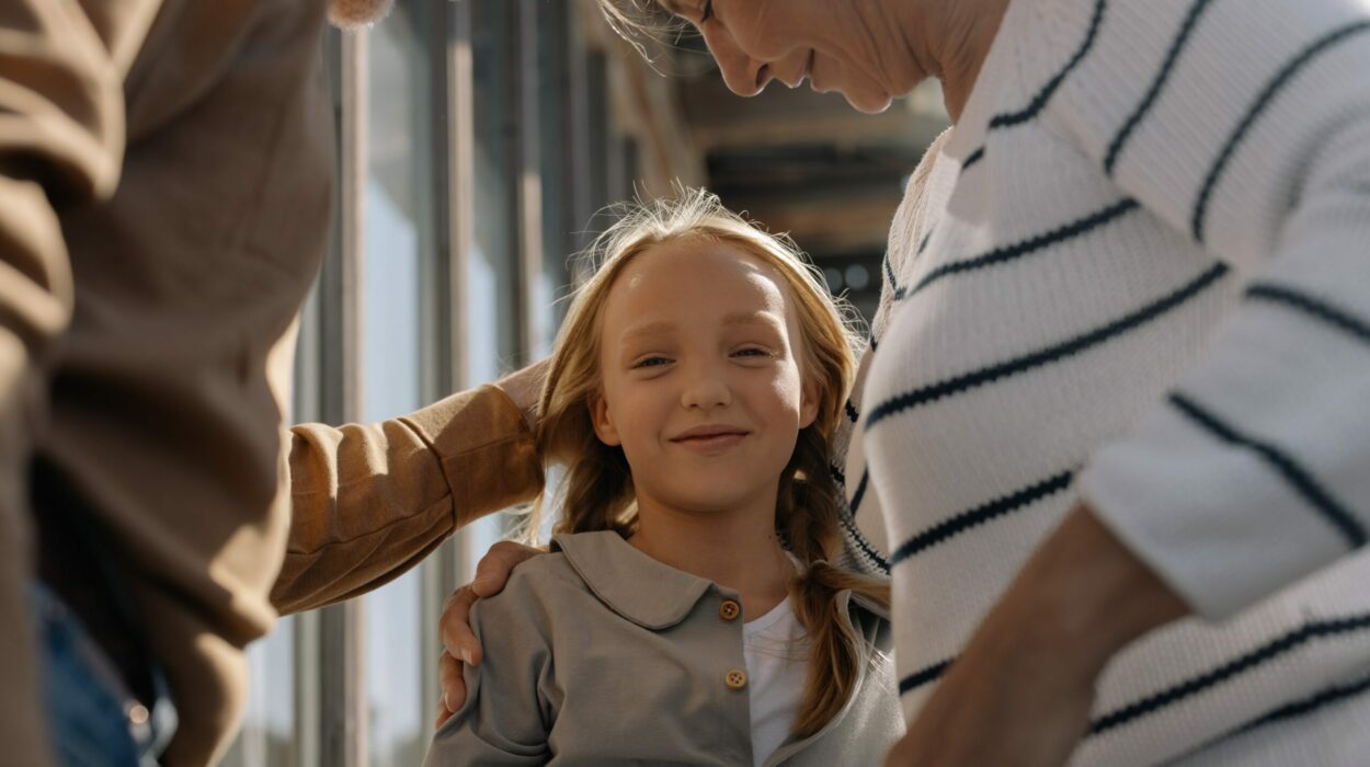 Two grandparents are holding their granddaughter that is smiling at the camera