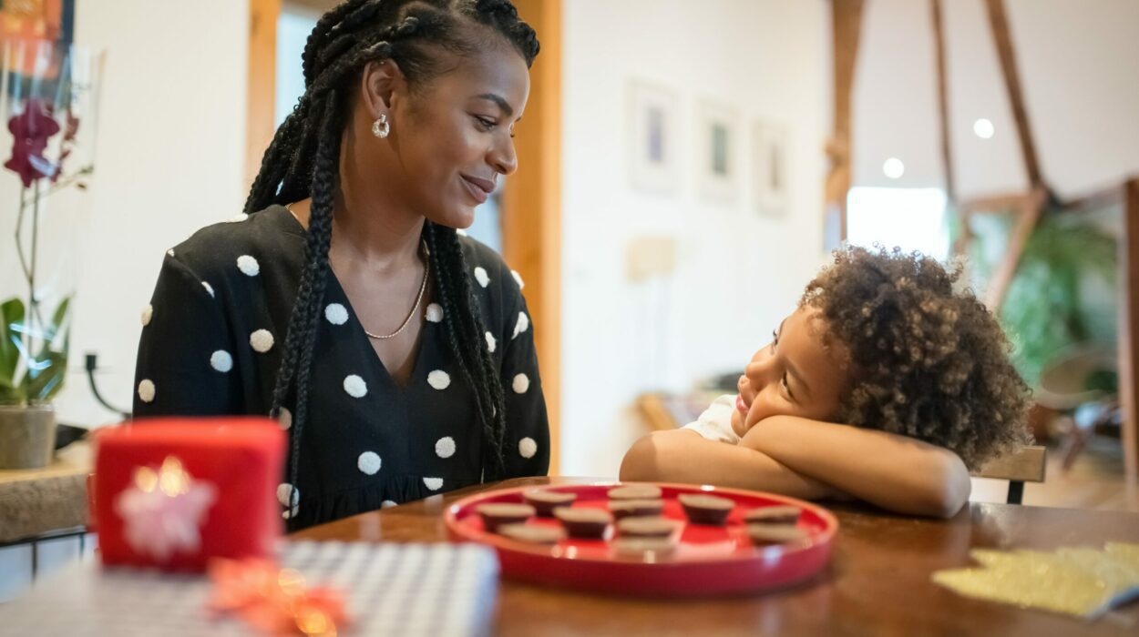 Mother and son looking at each other inside their house at a table