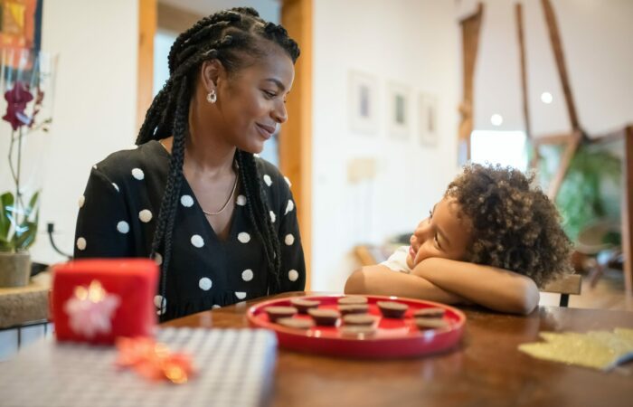 Mother and son looking at each other inside their house at a table