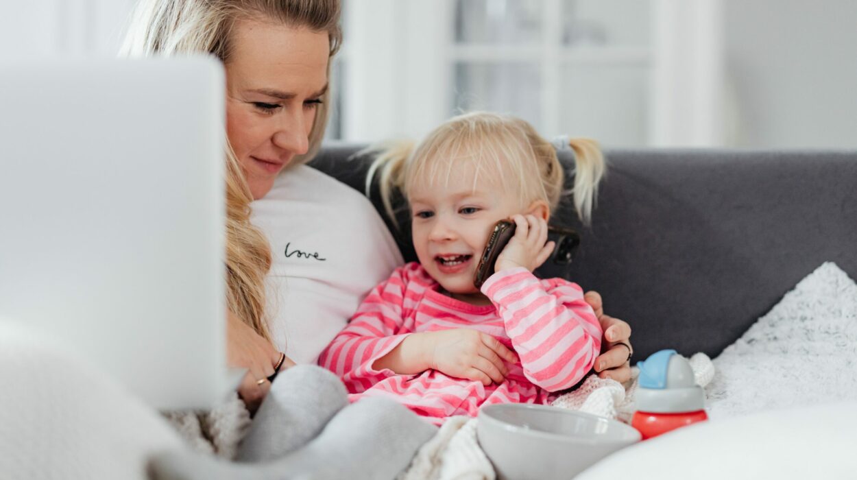 Woman holding a laptop is looking at her daughter using a mobile phone for a phone call