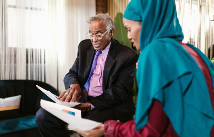 Man and woman discussing business holding print outs