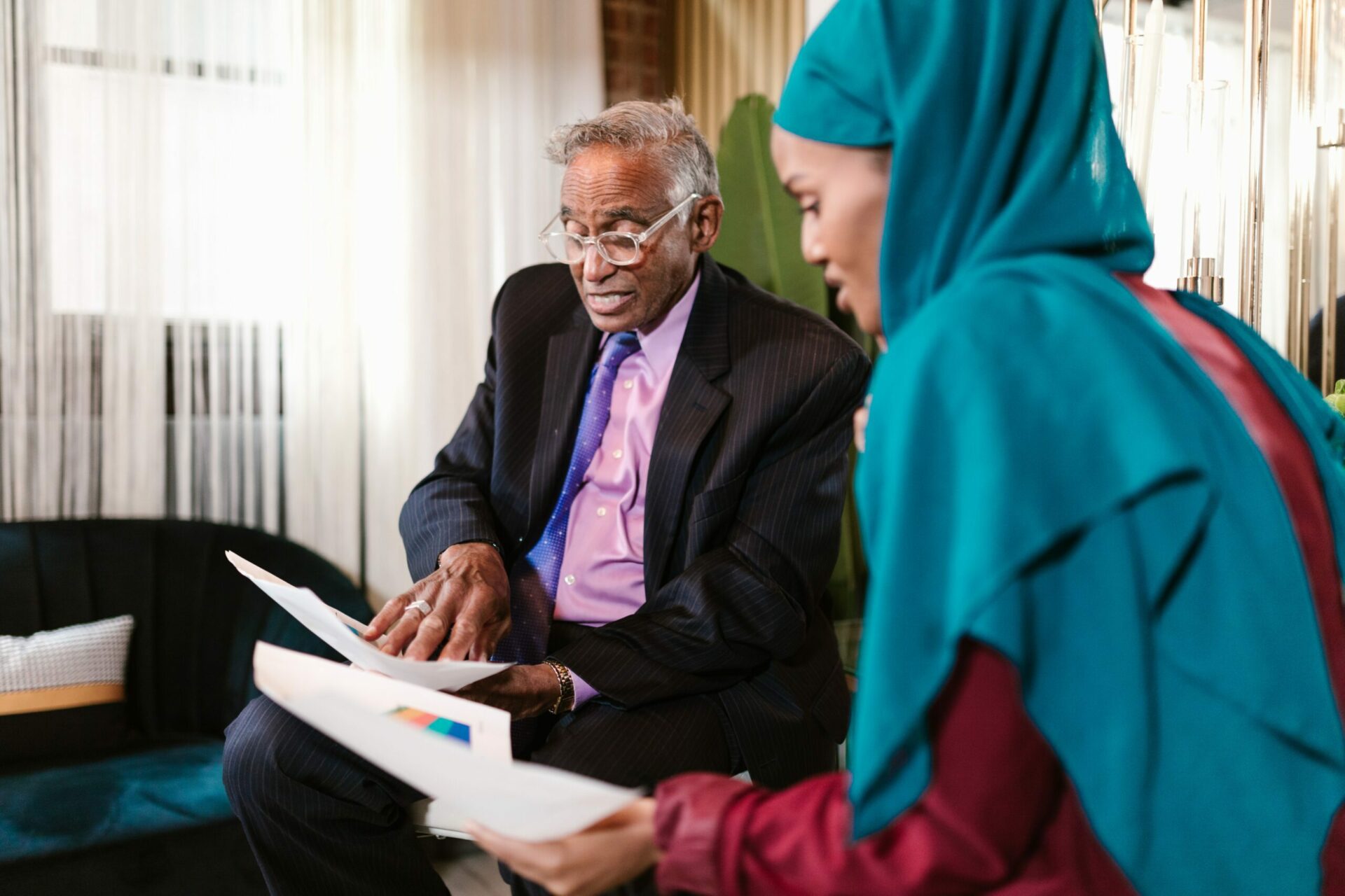 Man and woman discussing business holding print outs