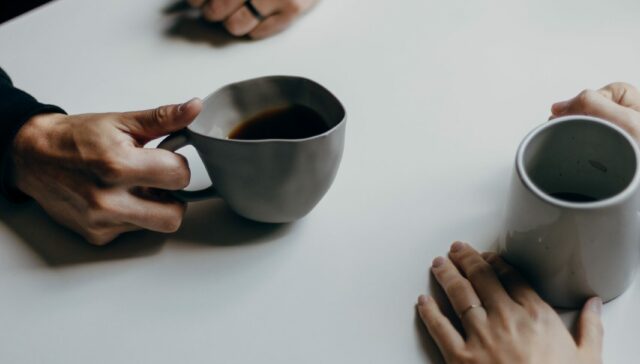 Close up of two people having a conversation over coffee