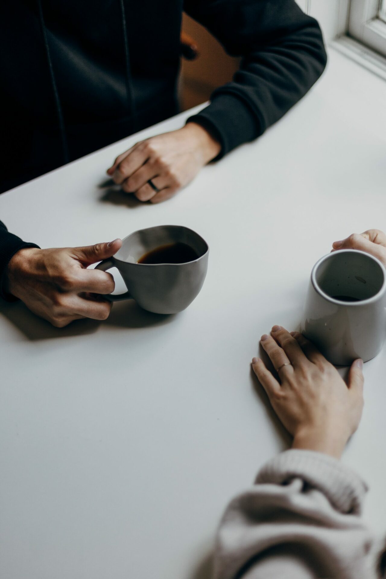 Close up of two people having a conversation over coffee