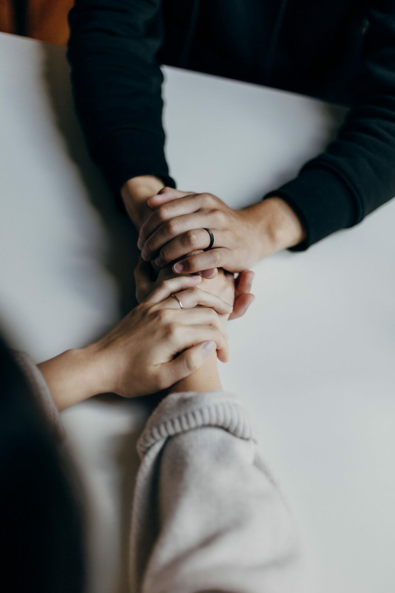 Close up of two people having a conversation and holding hands in support