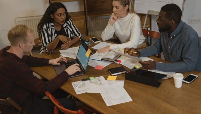 A group of people sitting around a table in an office.