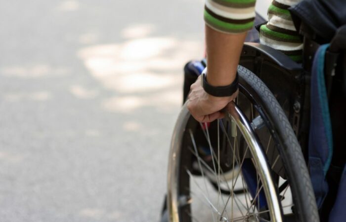 A person in a wheelchair is holding the wheel.