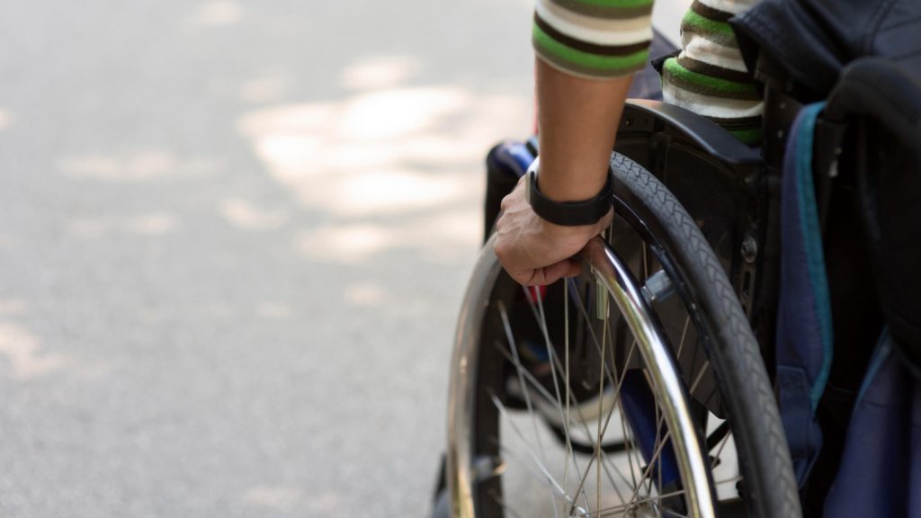 A person in a wheelchair is holding the wheel.
