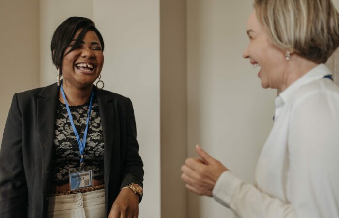 Two businesswomen laughing with each other.