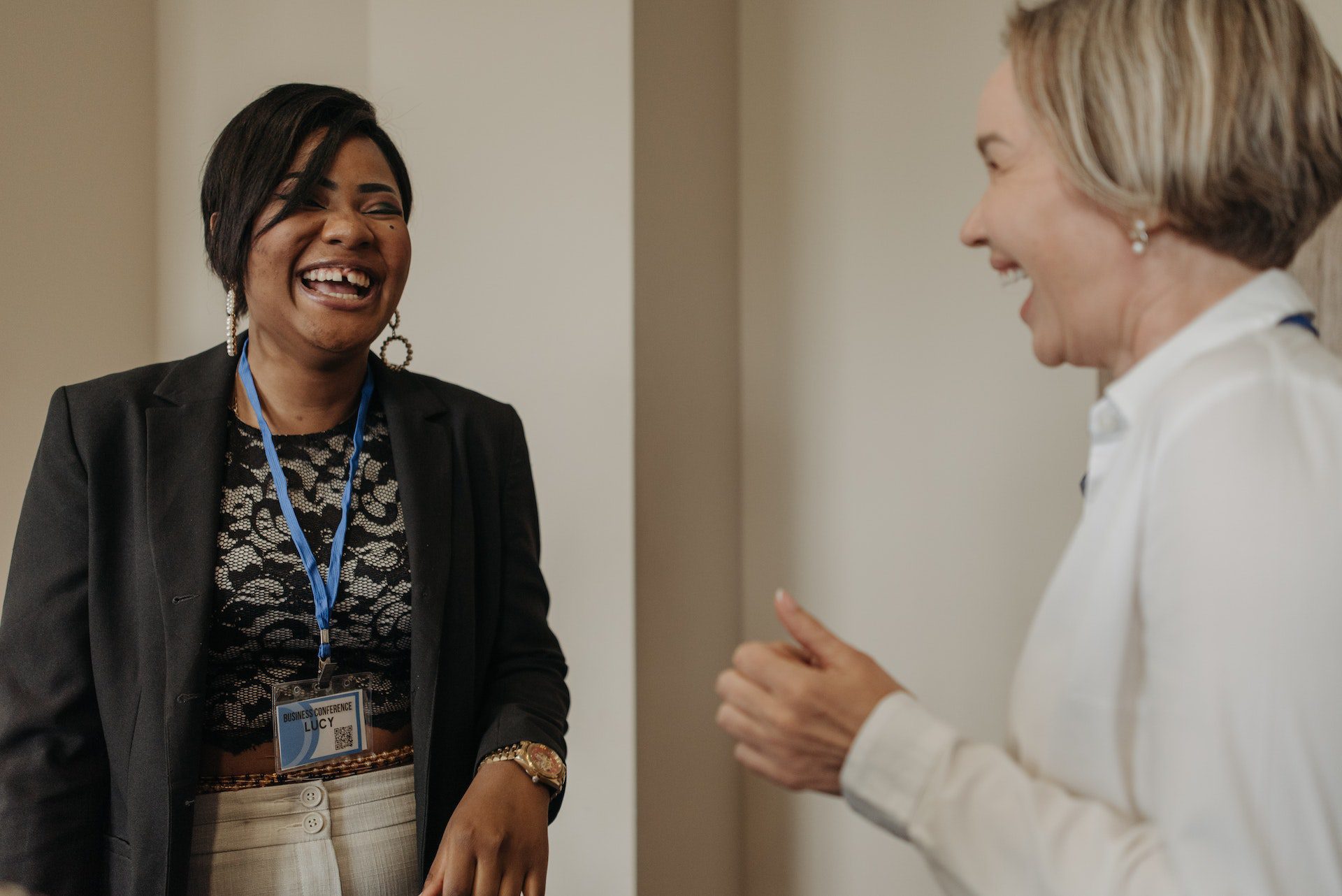 Two businesswomen laughing with each other.
