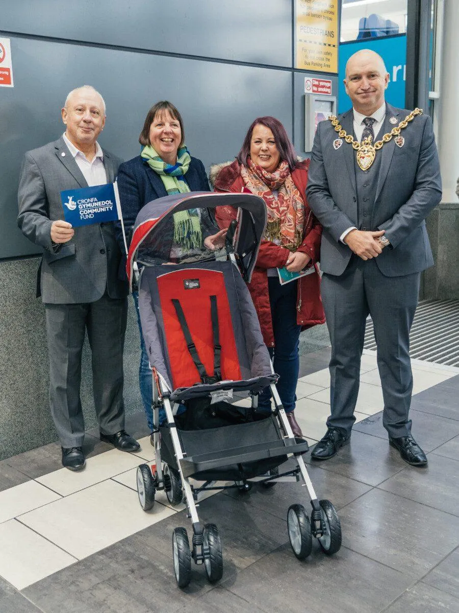 BJC04932 A group of people standing around a disability pushchair. Those people are Peter Howell, Jo young, Catriona Learmont and Cllr Andy Williams (Mayor)