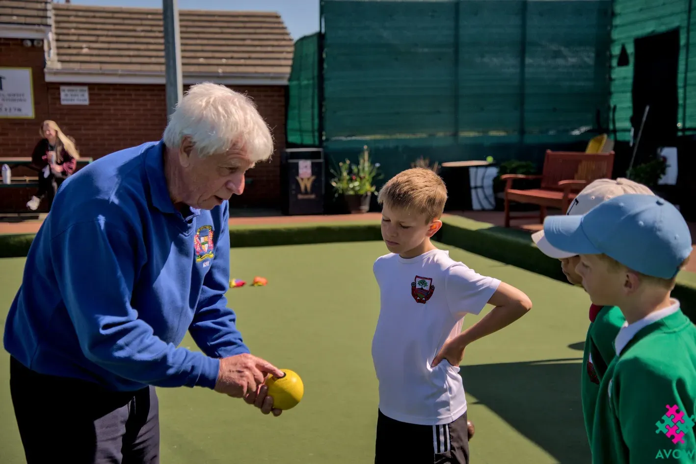 Intergenerational Week - Bradley Bowling Club - Old man showing young boys to bowl.