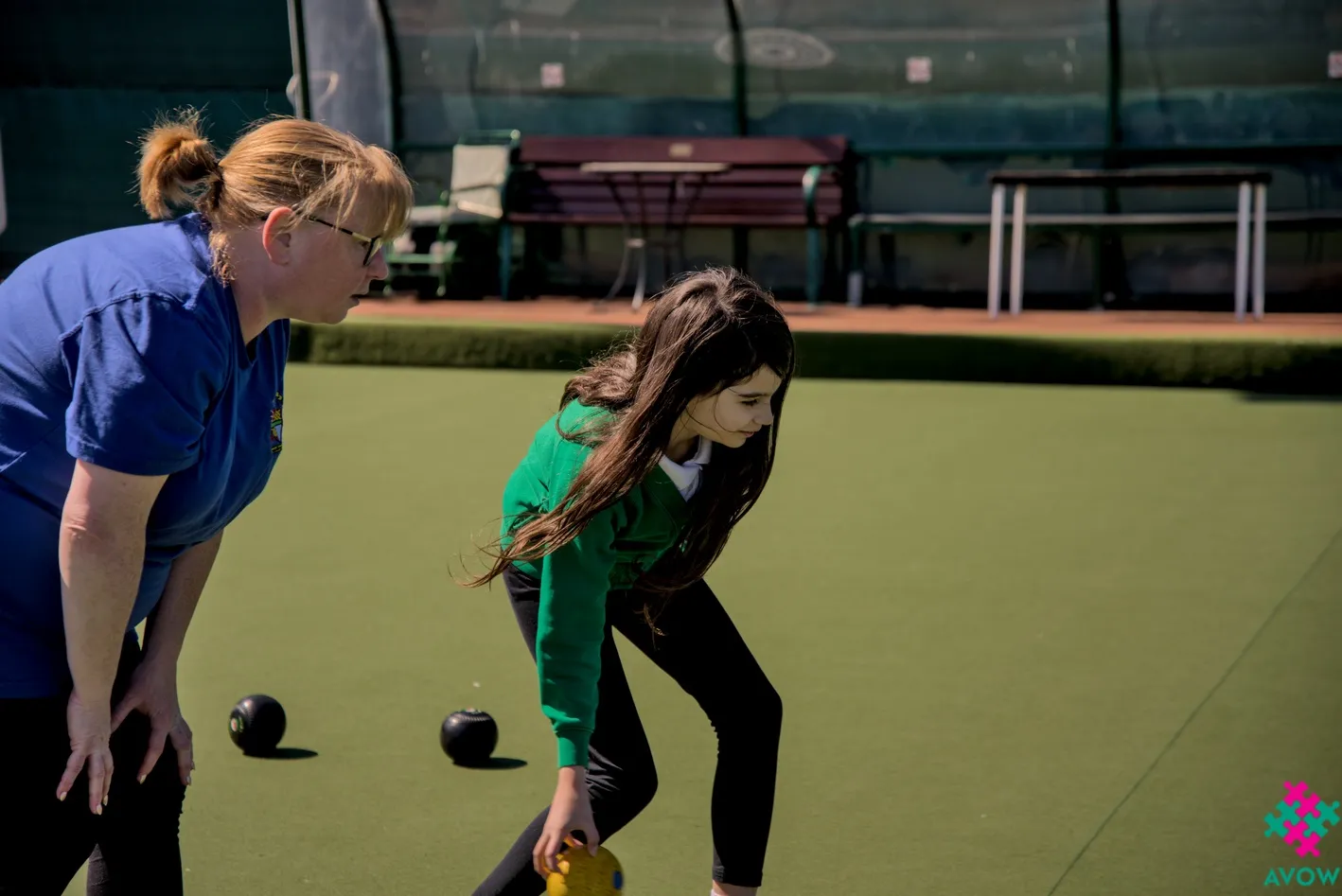 Intergenerational Week - Bradley Bowling Club - Woman teaches young girl to bowl