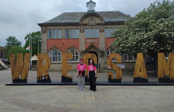 AVOW Volunteers infront of the Wrecsam sign in Queen's Square