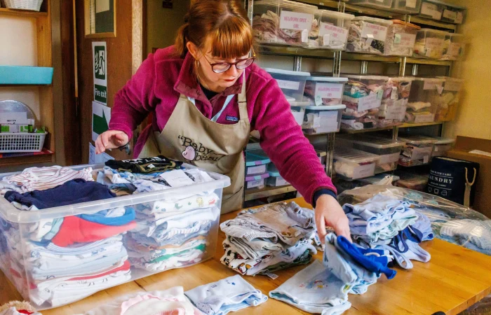 Baby Basics: Women sorting clothes.